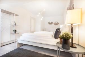 Un dormitorio blanco con una cama grande y una mesa en CenterApartment, WIFI, SmartTV, full Kitchen, Netflix, Pottbude in Essen en Essen