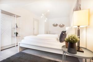 a white bedroom with a large bed and a table at CenterApartment, WIFI, SmartTV, full Kitchen, Netflix, Pottbude in Essen in Essen