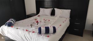 a white bed with red flowers on it at Uni sharm aqua park in Sharm El Sheikh