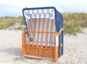 una silla de playa sentada en la arena de la playa en Hus-Hiddensee, en Vitte