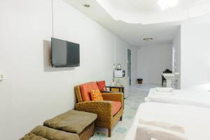 Cette chambre dispose de 2 chaises et d'une télévision murale. dans l'établissement High5 Guesthouse, à Pattaya