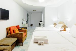 une chambre d'hôtel avec trois lits et un canapé dans l'établissement High5 Guesthouse, à Pattaya