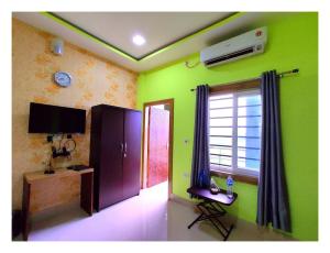 a room with green walls and a tv and a window at Green Vista Resort in Chālsa