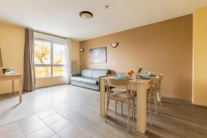 a living room with a table and a couch at Zenitude Hôtel-Résidences Magny-les-Hameaux in Magny-les-Hameaux