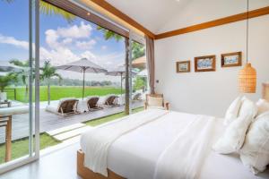 a bedroom with a bed and a large glass window at Villa Noemie by BaliSuperHost in Ubud