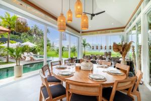 comedor con mesa, sillas y piscina en Villa Noemie by BaliSuperHost en Ubud