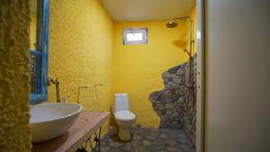 a yellow bathroom with a sink and a toilet at Melaanian Vintage - Guest House, Ecotourism Complex in Gurjaani +39 photos