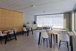 un restaurante con mesas y sillas y una gran ventana en Wijndomein Zwaeneberg en Voeren