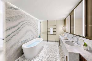 a bathroom with two sinks and a large marble wall at Mandarin Oriental, Lago di Como in Blevio