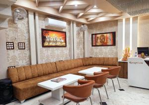 un ristorante con divano, 2 tavoli e frigorifero di V SQUARE AIRPORT HOTEL a Lucknow