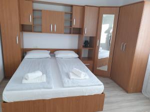 Un dormitorio con una cama con almohadas blancas. en Apartamente la rezidenta noua ideale vacanze job etc en Chişoda