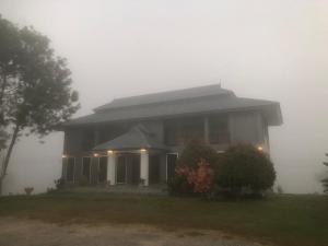 a house in the fog with a house at เชียงของฮิลล์ รีสอร์ท 