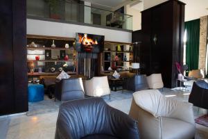 eine Lobby mit Stühlen und einem Tisch und einem Fernseher in der Unterkunft Hôtel du Golf Mohammedia in Mohammedia
