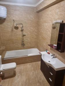 a bathroom with a tub and a toilet and a sink at Askyhomes in Hurghada