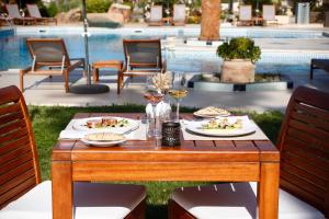 una tavola con piatti di cibo e bicchieri di vino di Hotel Corsica & Spa Serena a Calvi