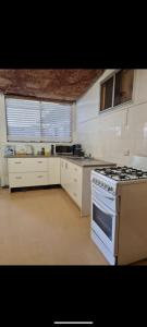a kitchen with a stove top oven in a room at Desert Gum Grund st in Coober Pedy