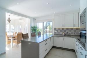 una cucina con armadi bianchi e una sala da pranzo di Villa Sandra Luxury Suite a Nerja