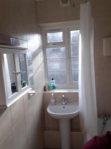 baño con lavabo y ventana en Primary bedroom with king size bed in 3 rooms apartment, en Londres