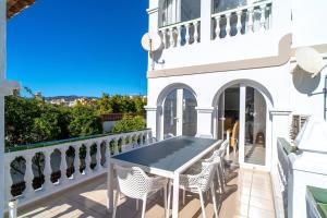 patio con mesa y sillas en el balcón en Villa Sandra Luxury Suite, en Nerja
