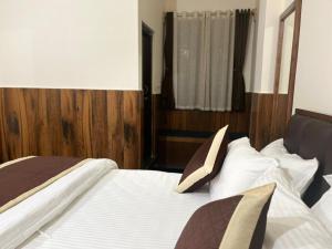 a bedroom with two beds and a wooden headboard at Dzomo Homestay in Gangtok