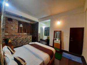 a bedroom with two beds and a brick wall at Dzomo Homestay in Gangtok