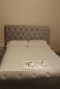 uma cama com dois chinelos em cima em Primary bedroom with king size bed in 3 rooms apartment em Londres
