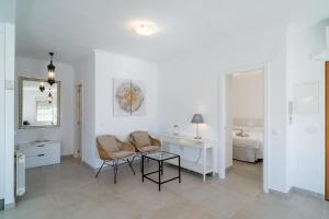 Camera bianca con tavolo, sedie e letto di Villa Sandra Luxury Suite a Nerja