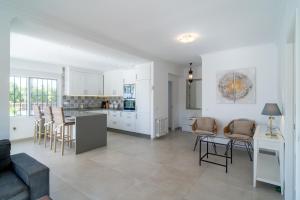 una cucina e un soggiorno con tavolo e sedie di Villa Sandra Luxury Suite a Nerja