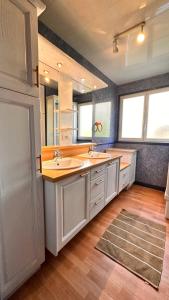 duża łazienka z 2 umywalkami i 2 lustrami w obiekcie Gîte Le Pingu - spacieux, calme, plein sud - cabine sauna - 8 personnes w mieście La Bresse
