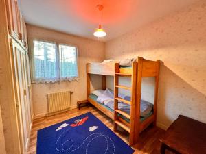 Cette chambre comprend 2 lits superposés et un tapis. dans l'établissement Gîte Le Pingu - spacieux, calme, plein sud - cabine sauna - 8 personnes, à La Bresse