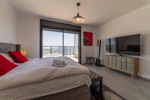 a bedroom with a large bed and a large television at Bautiful Penthouse 4Bed with Jacuzzi sea view in Tel Aviv