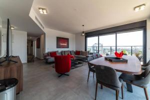 a living room with a table and chairs and a couch at Bautiful Penthouse 4Bed with Jacuzzi sea view in Tel Aviv