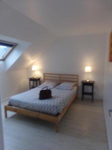 Un dormitorio con una cama con una mochila. en L'Escapade Mersoise en Mers-les-Bains