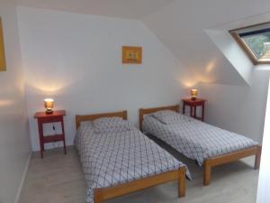 2 camas en una habitación con 2 luces en la pared en L'Escapade Mersoise en Mers-les-Bains