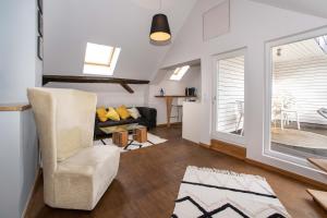 a living room with a chair and a couch at Hotel Fuchs "Life-Style mit Night-Life" in Saarbrücken