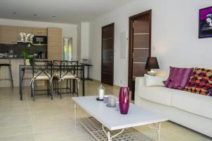 a living room with a white couch and a table at La villa Roméo, piscine et spa in Sainte-Maxime