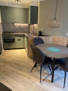 a kitchen with a table and chairs in a room at Puur Texels 6 in De Koog