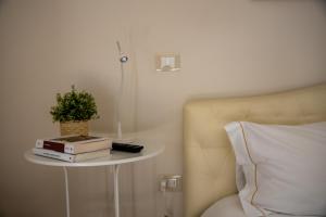 uma mesa com livros e uma planta ao lado de uma cama em Borgomurgia em Andria