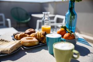 uma mesa com um prato de pastelaria e duas chávenas de sumo de laranja em Borgomurgia em Andria