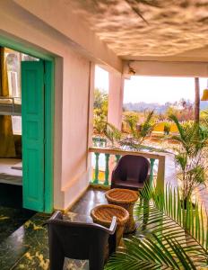 a balcony with chairs and a green door and a window at TTH in Goa Velha