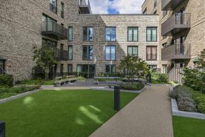 a courtyard in a building with green grass at Rooms in Shared Luxury Flat in London