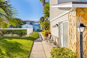 a walkway next to a house with chairs at Beachy Keen Cottage in Clearwater Beach