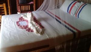 a bed with white sheets and flowers on it at Jao bay boat charter in Talibon