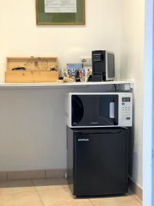 un forno a microonde seduto sopra un frigorifero accanto a un bancone di B&B Fashion style a Cagliari