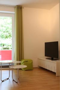 sala de estar con mesa y TV en Travel Apartments en Münster