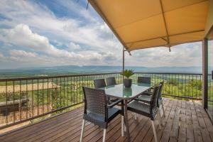 a table and chairs on a deck with a view at Idwala Le Ingwe Lodge in Hekpoort