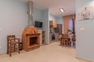 a kitchen and living room with a brick fireplace at Villa Vimani in Paestum