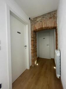 an empty room with a brick wall and a door at Teodorico Room & Apartment in Verona