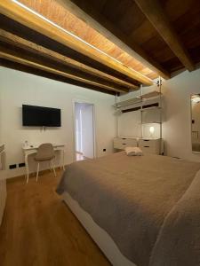 a bedroom with a bed and a desk and a tv at Teodorico Room & Apartment in Verona