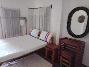 a bedroom with a bed and a mirror and a chair at Jao bay boat charter in Talibon